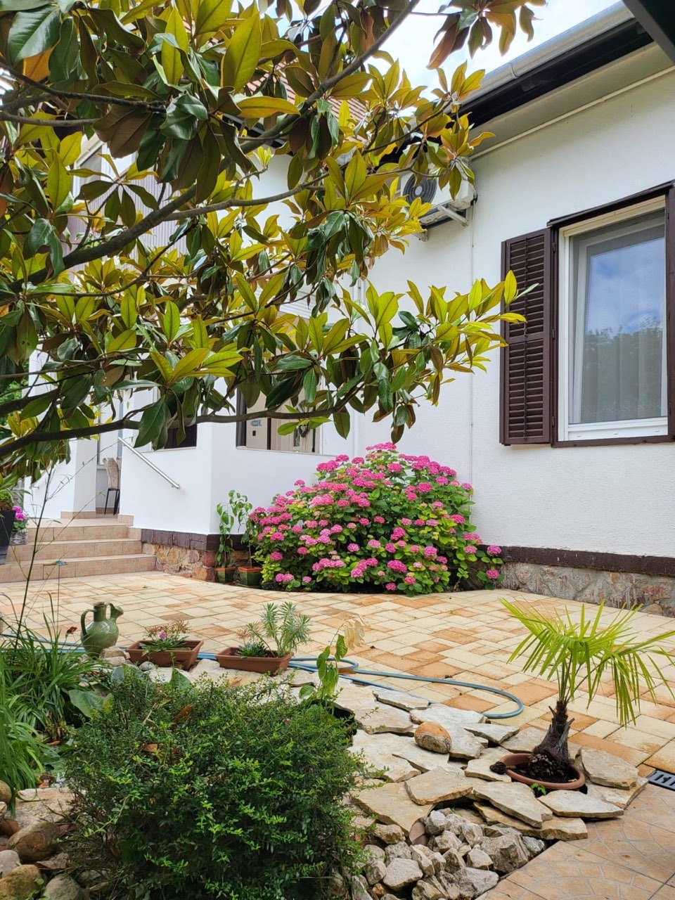 A Krisztina Villa hangulatos, virágos udvara Balatonlellén